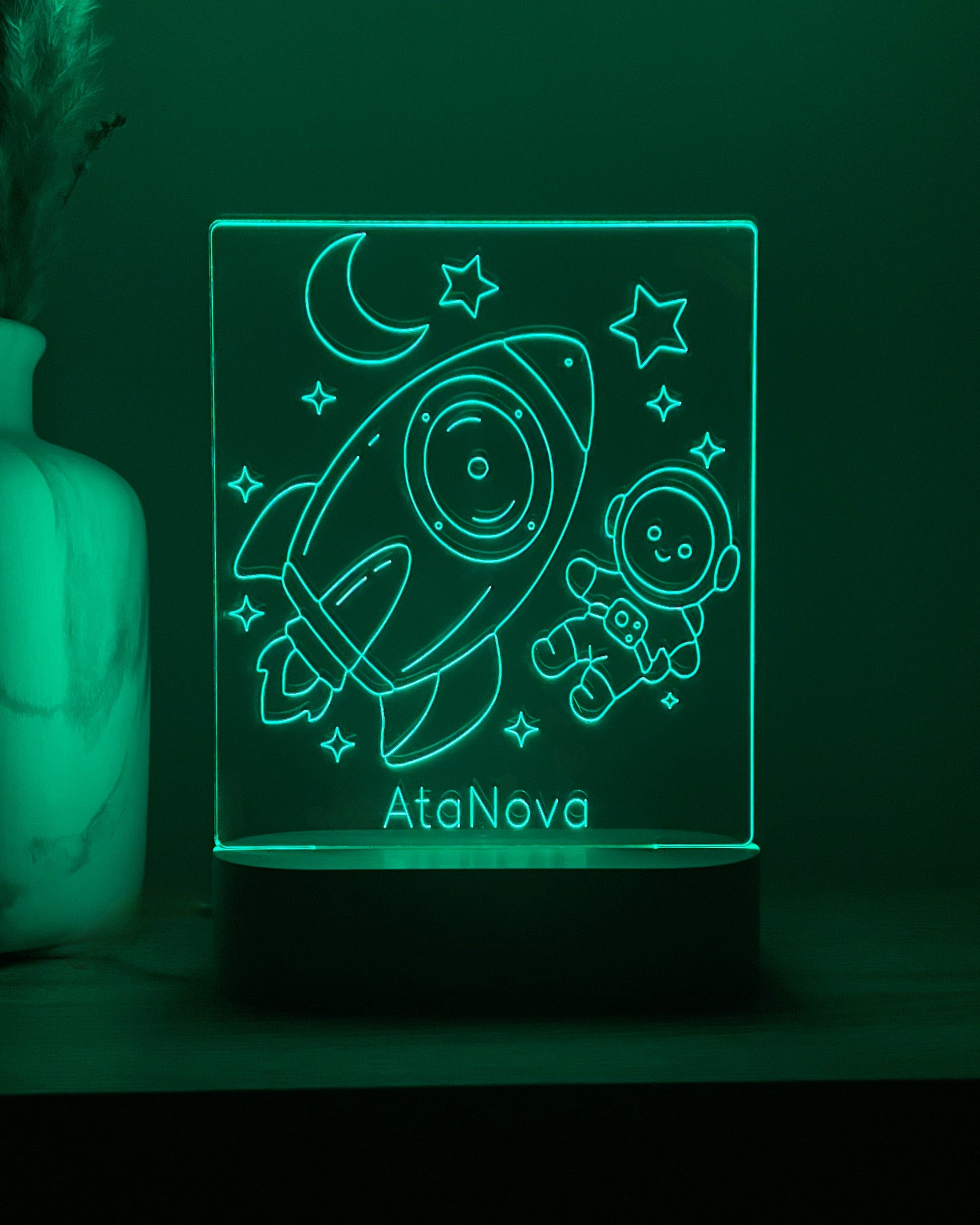 DreamLight™-nachtlampje met groene verlichting, raket, astronaut en de tekst AtaNova