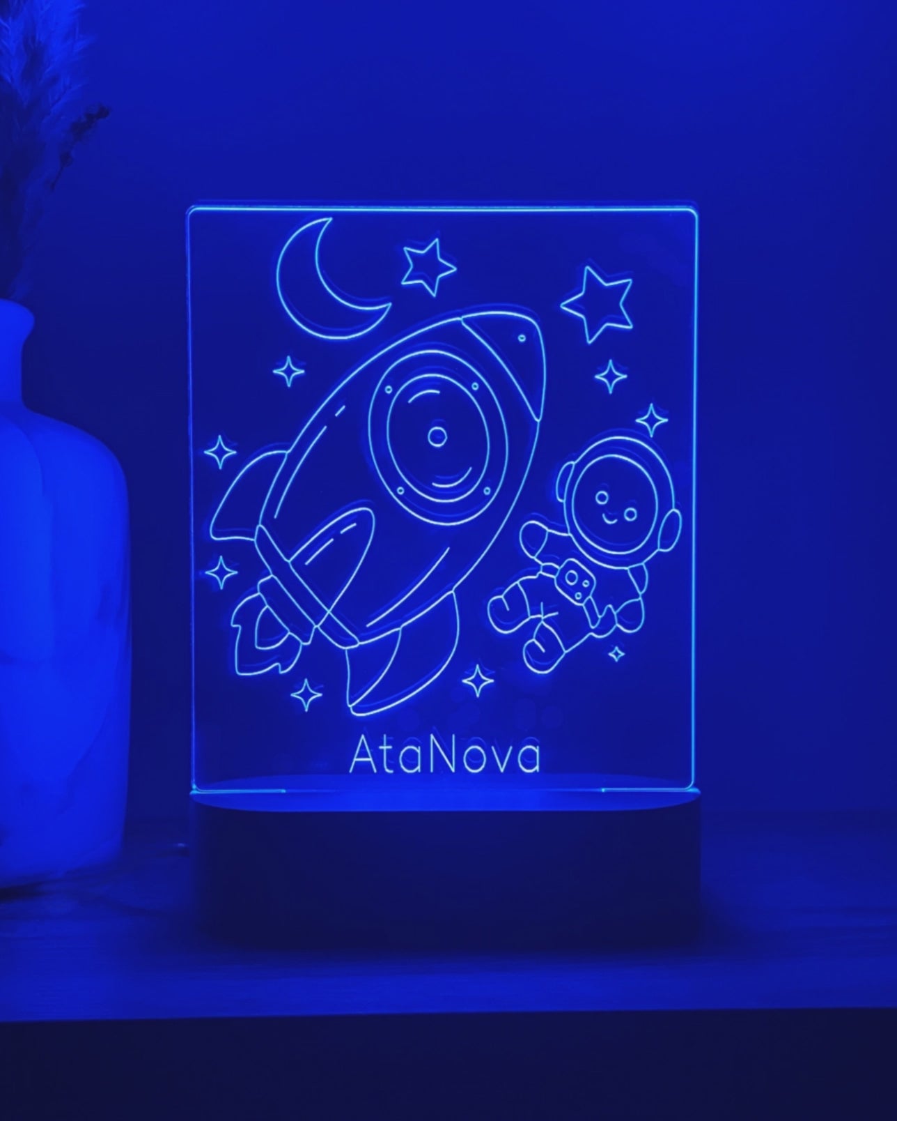 Video van een blauw verlicht DreamLight™-nachtlampje met raket, astronaut en de tekst AtaNova