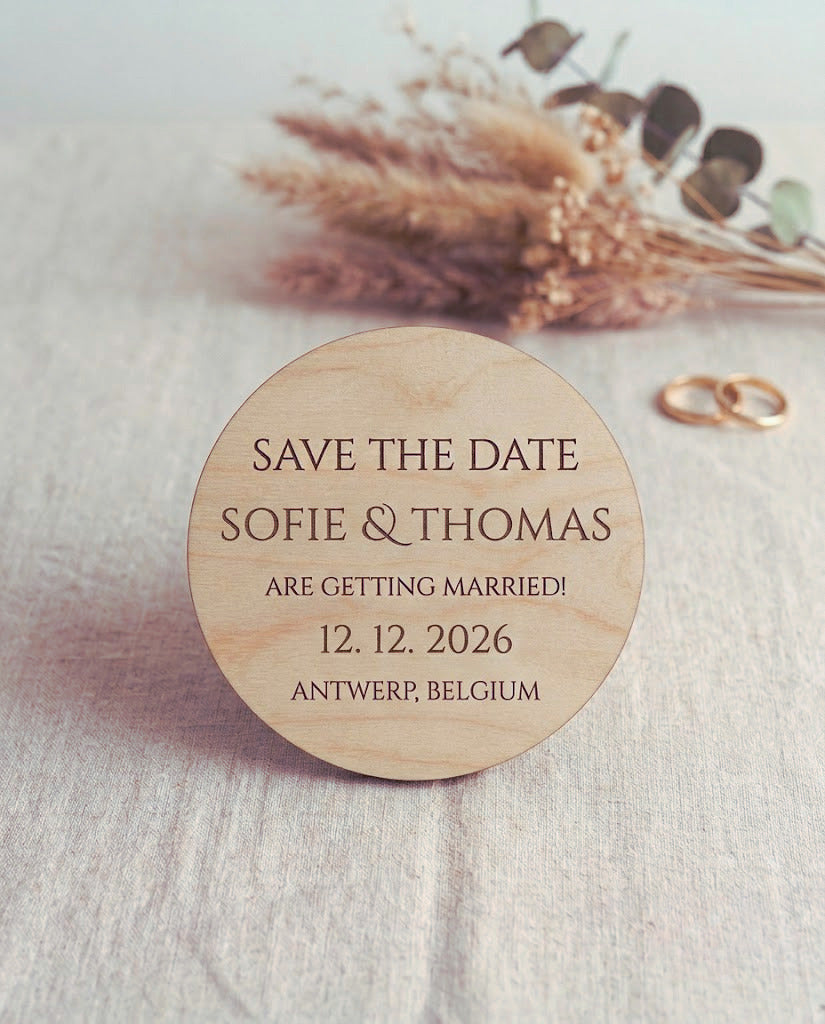 Ronde houten Save the Date-magneet voor Sophie & Thomas op een envelop